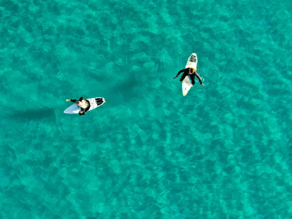 Вид з повітря на серфері, що чекає, веслує і насолоджується хвилями в красивій блакитній воді — стокове фото