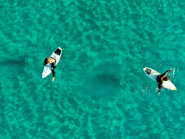 Вид з повітря на серфері, що чекає, веслує і насолоджується хвилями в красивій блакитній воді — стокове фото