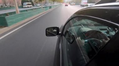 Pekin yolundaki arabanın yan görüntüsü ve sürücüsü.