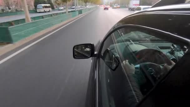 Boční pohled na auto a řidiče uvnitř vozu na silnici v Pekingu — Stock video