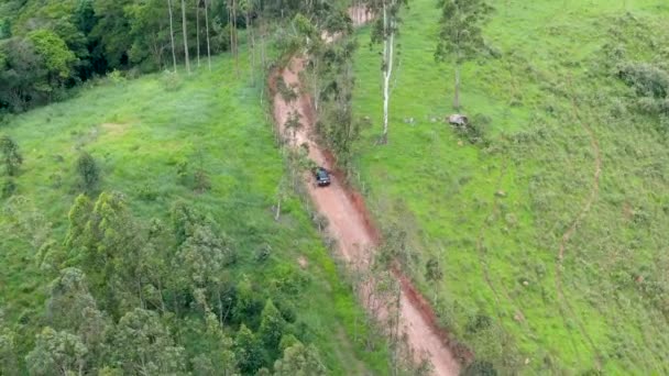 Flygfoto över bilen kör genom en liten grusväg i mitten av grön tropisk dal. — Stockvideo