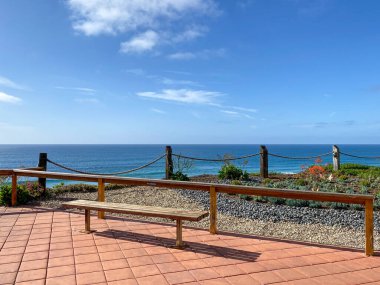 Uçurumun tepesinden tahta banklı Solana Sahili manzarası