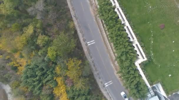 Luchtfoto van witte auto rijden op een kleine asfaltweg in een droge berg — Stockvideo
