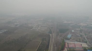 Pekin 'in dışındaki kırsal fakir köy aşırı kirlilik günlerinde tarım arazileri ve tren rayları ile
