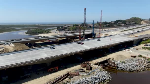 Vista aérea de la construcción de puentes de carretera sobre un pequeño río — Vídeo de stock