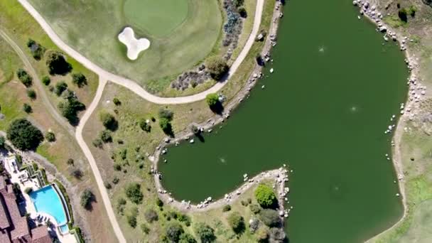 Вид с воздуха на большую роскошную виллу с бассейном, расположенную рядом с полем для гольфа в частном сообществе — стоковое видео