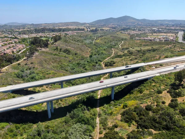 Aerial view of road highway bridge, viaduct supports in the valley among the green hills. — Stock Photo, Image