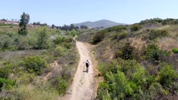 Letecký pohled na jízdu na horském kole v malé singletrack stezce v horách. — Stock video