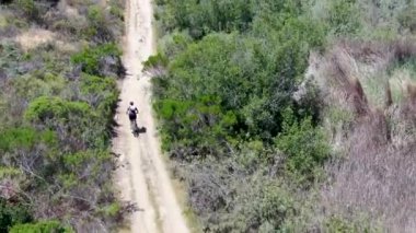Dağda küçük bir patikada dağ bisikleti sürmenin havadan görünüşü.