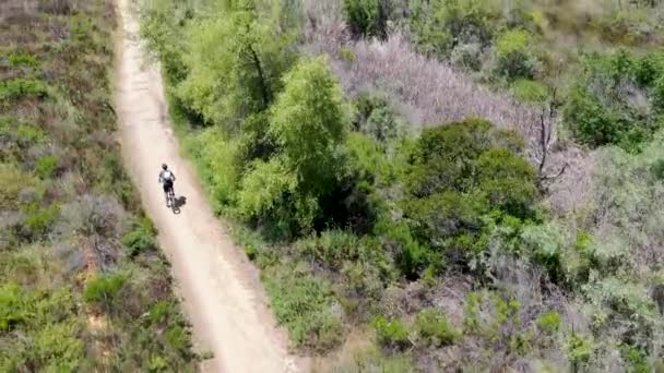 Vista aérea de montar en bicicleta de montaña en un pequeño sendero de una sola pista en la montaña . — Vídeos de Stock