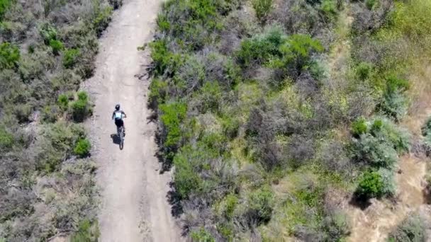 Letecký pohled na jízdu na horském kole v malé singletrack stezce v horách. — Stock video