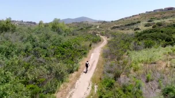 Letecký pohled na jízdu na horském kole v malé singletrack stezce v horách. — Stock video