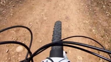 POV, dağda küçük tozlu bir patikada Rrding dağ bisikleti.