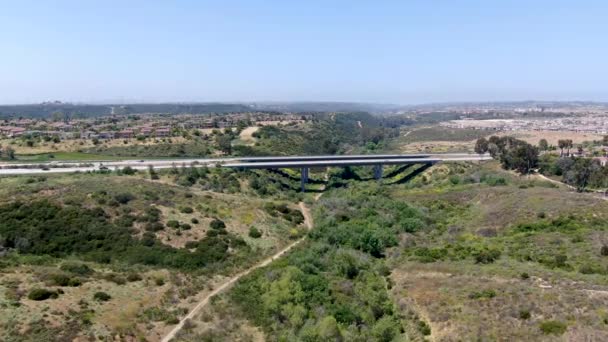 Karayolu köprüsünün havadan görünüşü, yeşil tepelerin arasındaki vadide viyadük desteği.. — Stok video