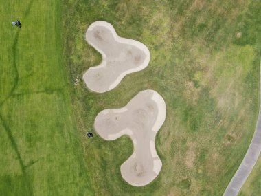 Güneşli bir günde yeşil bir golf sahasının havadan görünüşü