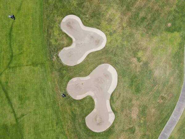 Vista aérea superior de um campo de golfe verde durante o dia ensolarado — Fotografia de Stock