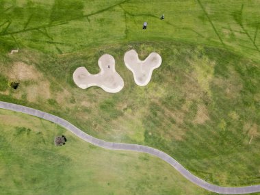 Güneşli bir günde yeşil bir golf sahasının havadan görünüşü
