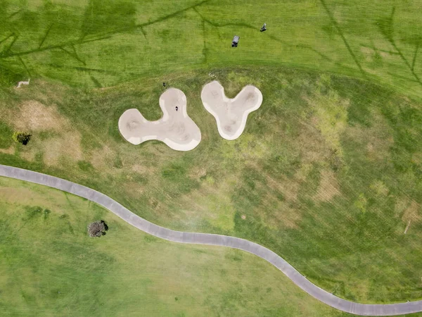 Güneşli bir günde yeşil bir golf sahasının havadan görünüşü
