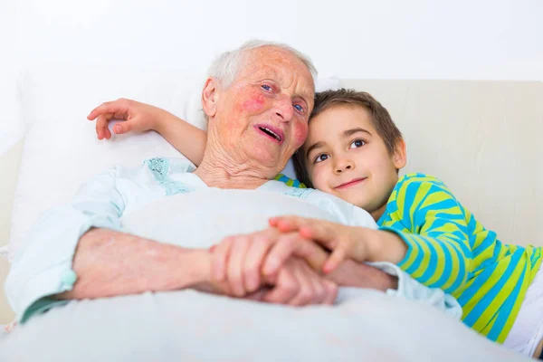 Großmutter und Enkel im Bett — Stockfoto