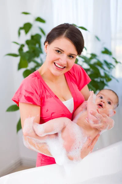 Mutter holt Baby aus Badewanne — Stockfoto