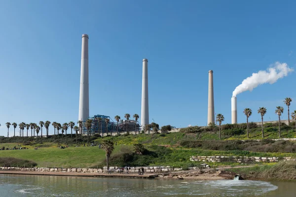 Mavi gökyüzüne karşı elektrik santrali bacalarından duman yükseliyor. Hadera, İsrail enerji santrali.