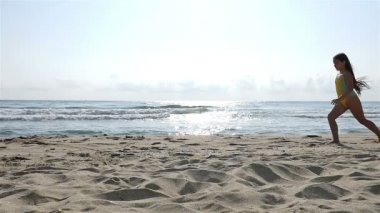 Deniz sahilde oynarken mayo, sevimli küçük bir kız, ağır çekim