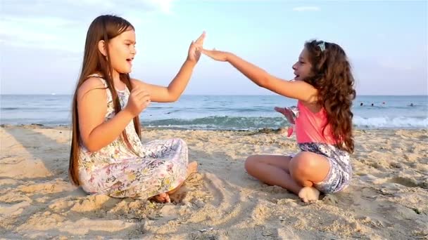Dvě malé holčičky hraje na pláži moře, pomalý pohyb — Stock video
