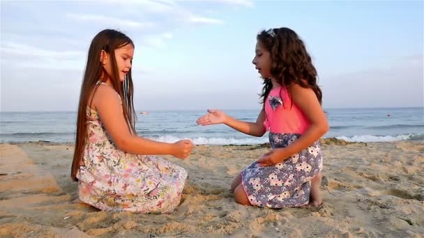 Twee kleine meisjes spelen op het strand van de zee, slow-motion — Stockvideo