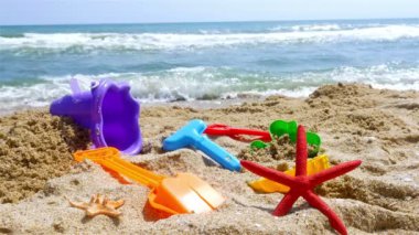 Kum oyuncakları içinde belgili tanımlık geçmiş dalgalar deniz sahilde
