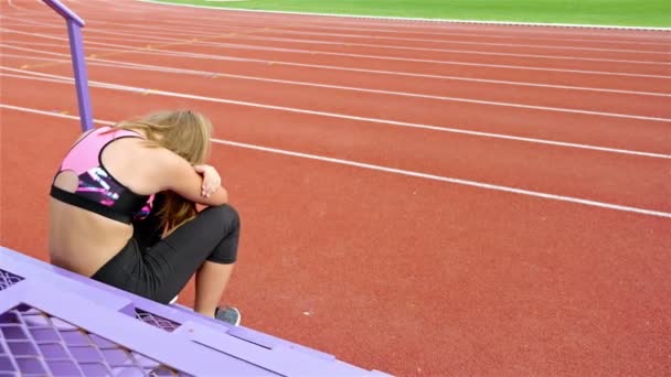 Tonåring flicka idrottsman att ta andetag trött utmattad besviken efter att ha kört på en stadium — Stockvideo