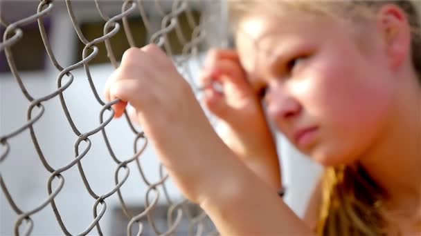 ティーンエイ ジャーの女の子の運動選手は競技場、スローモーションで金網を保持している怒っている不幸な失望悲しい — ストック動画
