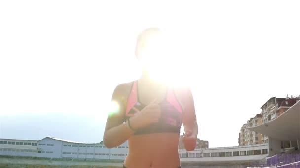 Steadicam снимок девушки-спортсмена, бегущей по стадиону, замедленная съемка — стоковое видео