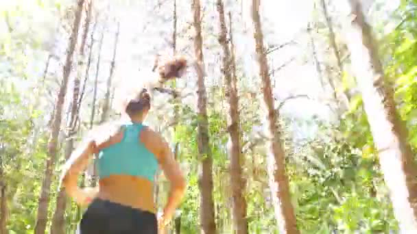 跟踪相机的女人女孩跑慢跑在公园里，木材，森林 — 图库视频影像