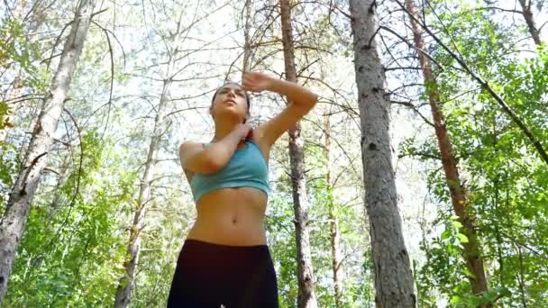 Tracking camera of woman girl warming up before running jogging in park, wood, forest — ストック動画