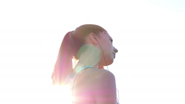 Nyomkövető kamera nő lány futás, kocogás, napraforgó mező fejhallgató — Stock videók