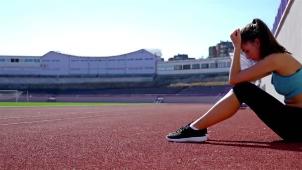 Desesperado decepcionado corredor de pista atleta mujer en un estadio, dolly — Vídeo de stock