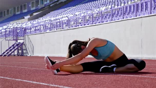 Nyomon követni a futó sportoló nő bemelegítés előtt futás-on egy stadion — Stock videók