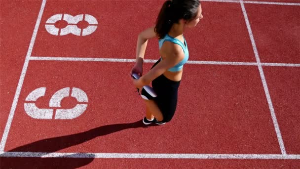 Lacak atlet pelari wanita pemanasan sebelum berjalan di stadion, top view — Stok Video