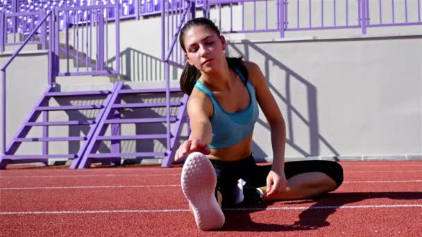 Corredor de pista atleta mujer calentando antes de correr en un estadio — Vídeos de Stock