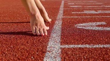 Başlangıç çizgisine ellerini koyarak runner kadın izlemek