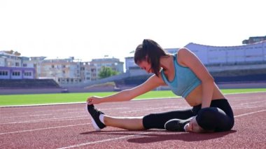 Bir stadyumda çalıştırmadan önce ısınma runner sporcu kadın izlemek
