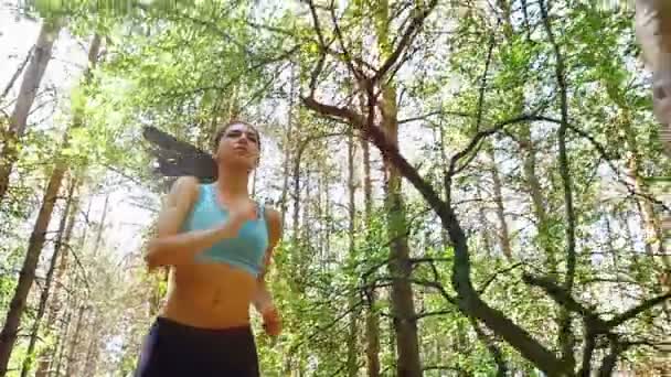 Cámara de seguimiento de la mujer chica corriendo corriendo en el parque, madera, bosque, cámara lenta — Vídeo de stock