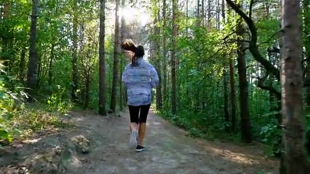 Tracking camera of woman girl running jogging in park, wood, forest, slow motion — Stock Video