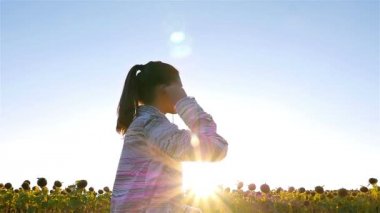 Ayçiçeği alanında, yavaş Koşu çalışan kulaklıklar ile kadın kız kamera izleme