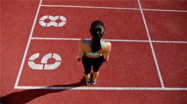 Bir Stadı'nda, ağır çekim çalıştırmadan önce ısınma parça runner sporcu kadın düşük açılı