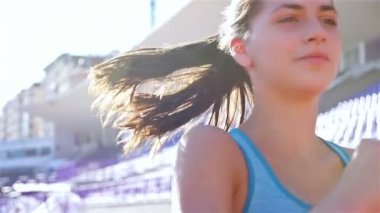 Bir Stadı'nda, yavaş çalışan bir parça runner sporcu kadın kız kamera izleme