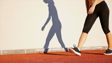 Runner kadın ve onun gölge çalıştırma hazırlığı, ağır çekim bir duvara izlemek
