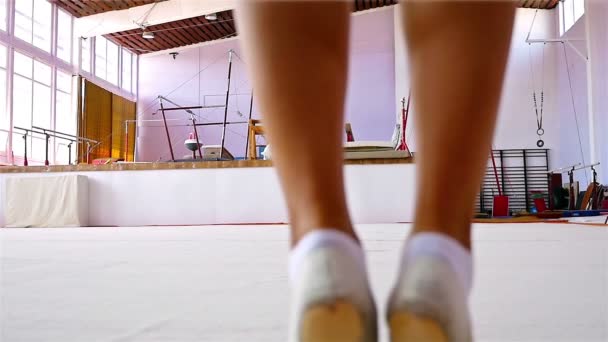 Тренування гімнастки на підлозі спортзалу, повільний рух — стокове відео