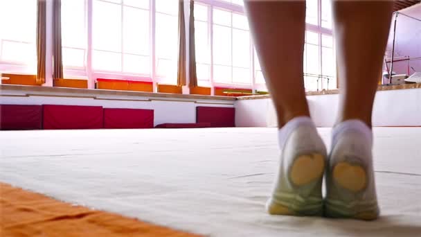 Тренування гімнастки на підлозі спортзалу, повільний рух — стокове відео
