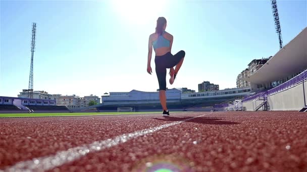 Śledzić kobieta lekkoatletka runner rozgrzewkę przed uruchomieniem na stadionie, w zwolnionym tempie — Wideo stockowe